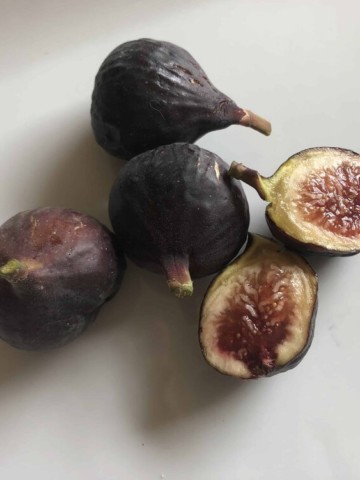 whole and cut figs on a white plate