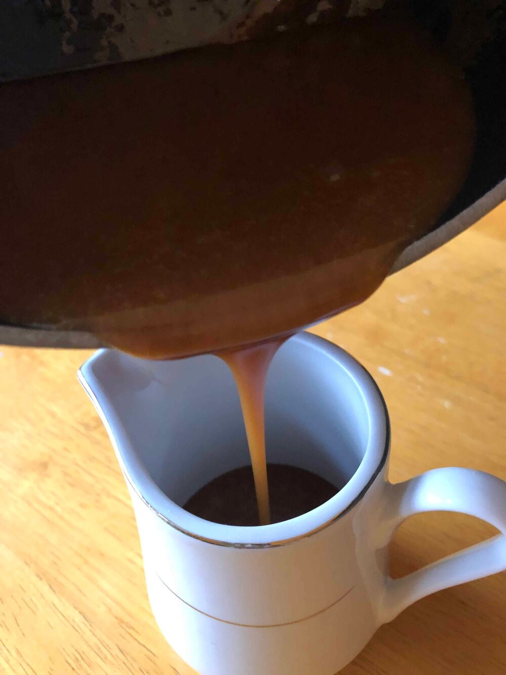 4 ingredient homemade sea salt caramel sauce being poured in to a serving dish