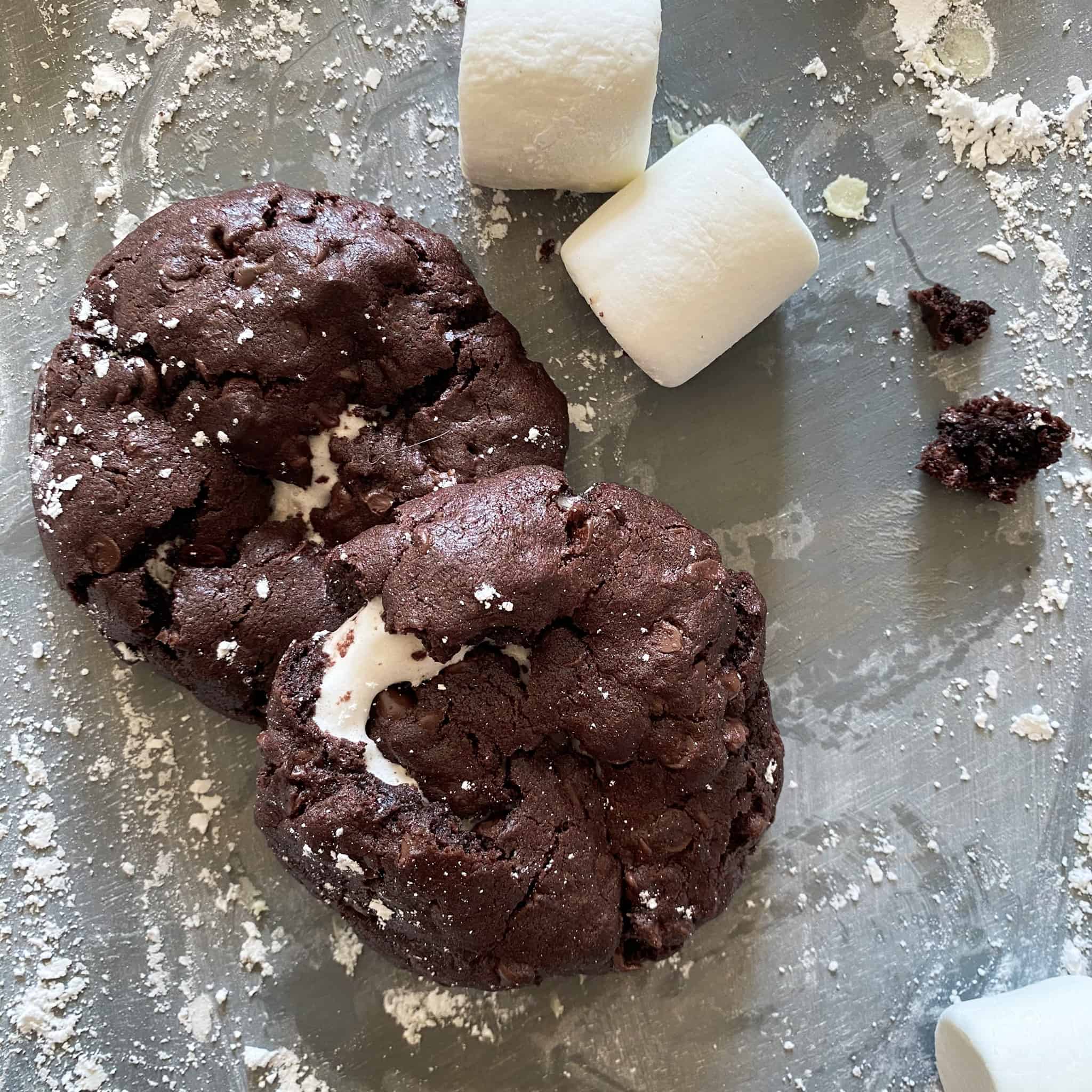 Hot chocolate cookies.  A dark chocolate cookie with a gooey center of marshmallow lava, surrounded by powdered sugar and marshmallows. 