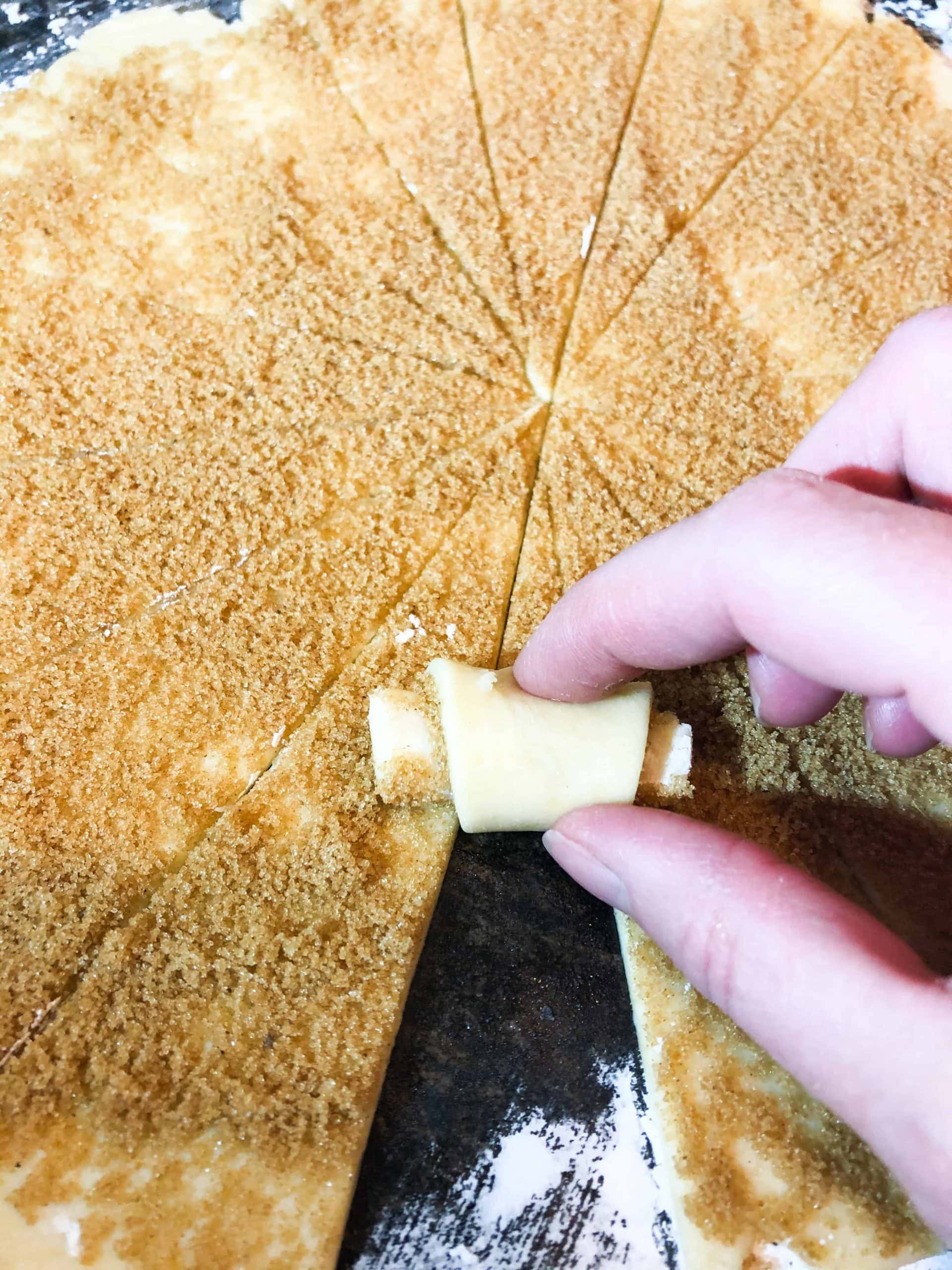 brown sugar cinnamon rugelach dough being shaped into crescents.  