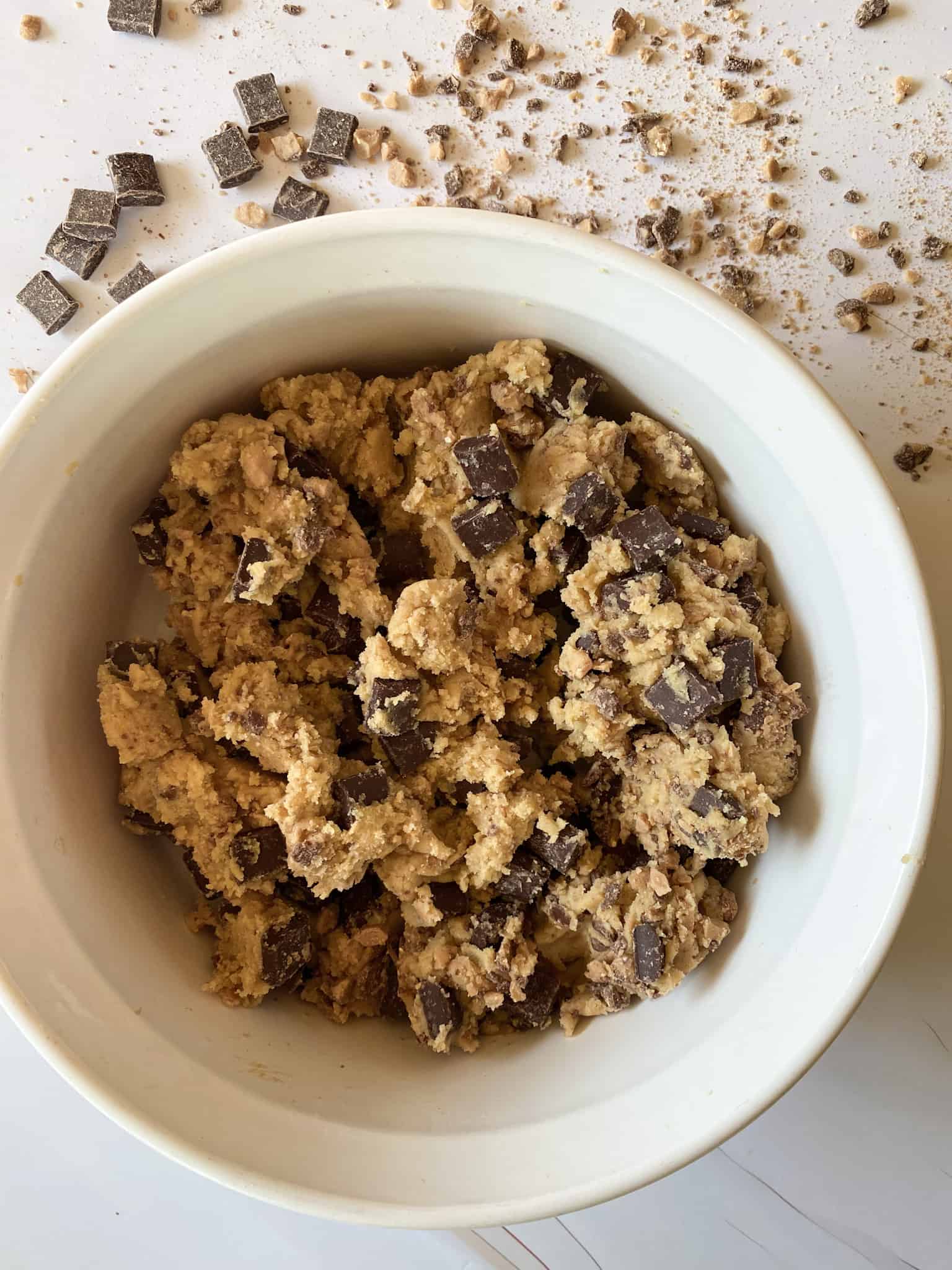 toffee chocolate chip cookie dough with chocolate chunks and toffee bits in the background