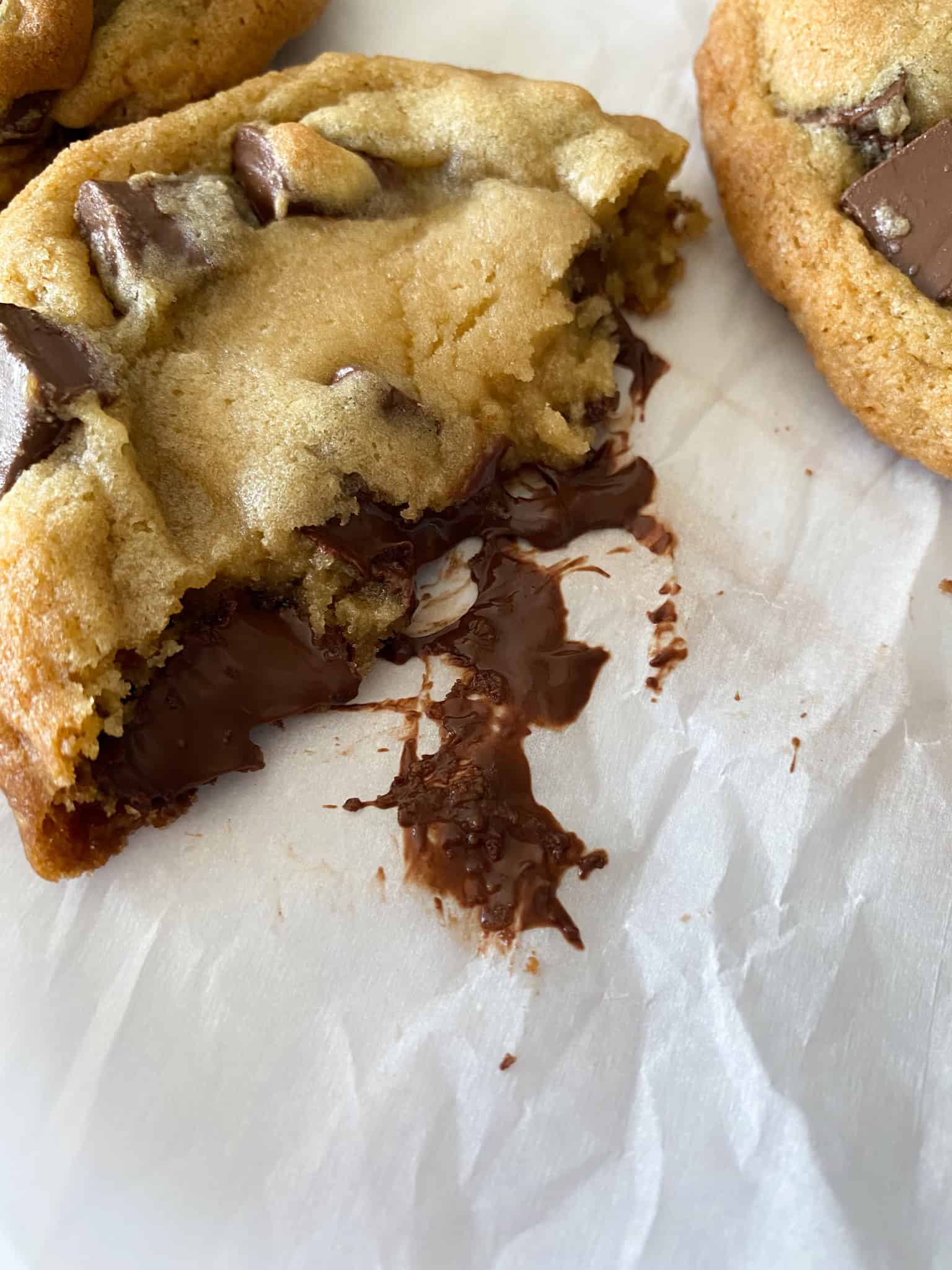 a gooey toffee chocolate chunk cookie cut open to reveal the ooey gooey center