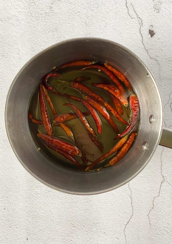 dried chili pods in simple syrup in a pot