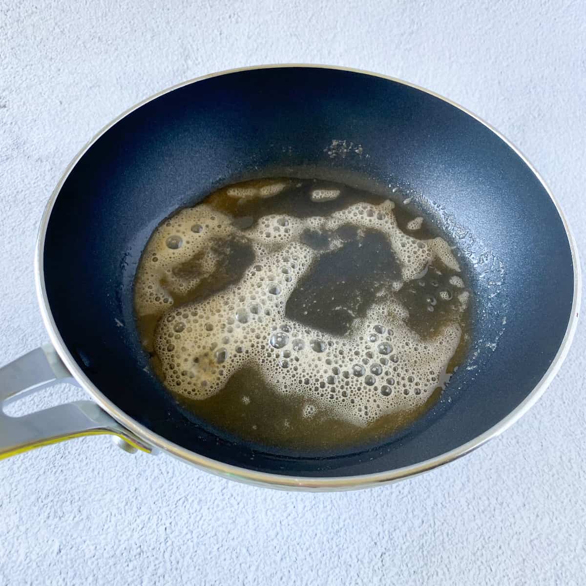 a pan of browned butter in preparation for olive oil buttermilk pancake batter to be poured in