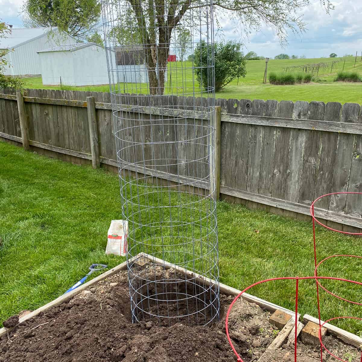 pumpkin tower placed in a large hole in a raised garden bed