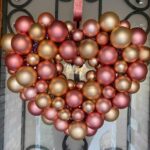 An inexpensive diy heart shaped Dollar Tree Valentine wreath hanging on a door.