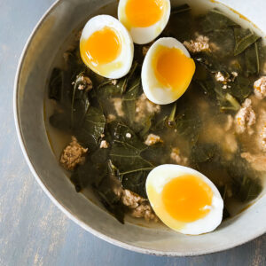green detox collard green ramen soup in a bowl with jammy eggs on top